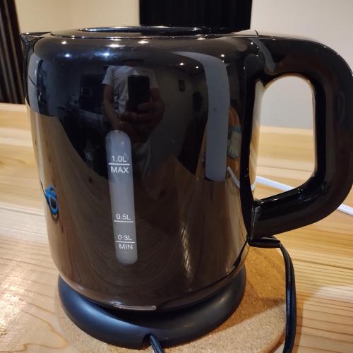 a reflection of a person taking a picture in a coffee pot at NorthHisath-Susukino in Sapporo