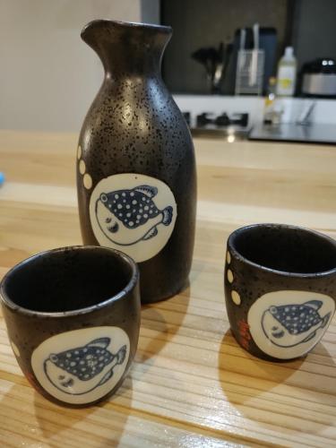 three cups sitting on a table with a vase at NorthHisath-Susukino in Sapporo