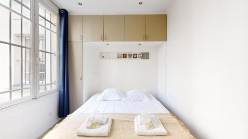 une chambre avec un lit avec deux serviettes dessus dans l'établissement Bluestay 2 - Appartement au Cœur de Paris, à Paris