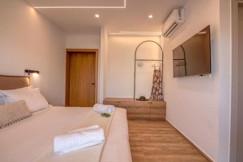 a bedroom with a bed and a tv on the wall at Kiwi Boutique Studios in Kissamos