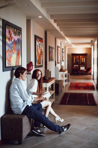 a man and woman sitting on a couch in a living room at Villasanpaolo Resort & Spa in San Gimignano