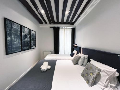 - une chambre avec 2 lits et un plafond noir et blanc dans l'établissement Urban Flat 69 - Beautiful Parisian Apartment in Center of Paris, à Paris