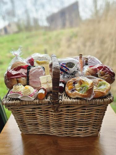 a basket filled with different types of bread on a table at Tiny House De Piiptsjilling in Westergeest
