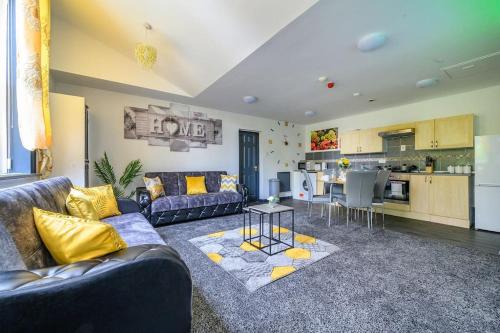 a living room with a couch and a table and a kitchen at -F5GH- For relaxed & Cosy stay, Free Parking, WiFi in Leeds