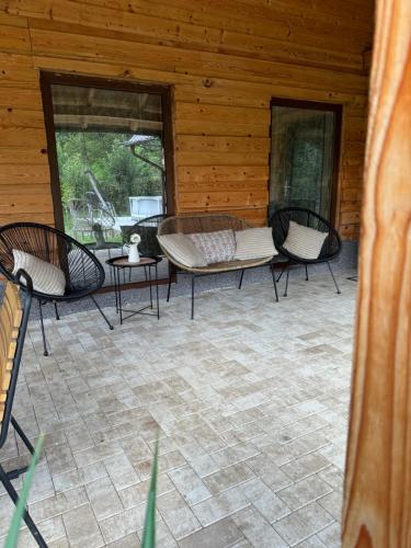 a patio with three chairs and a table on a cabin at ADORA River Retreat in Avrig