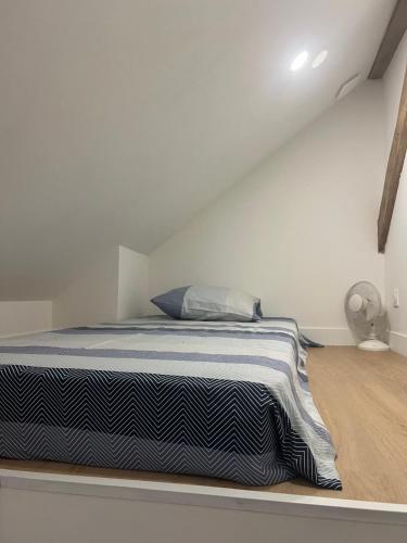 une chambre avec un lit dans une pièce blanche dans l'établissement Studio 5 minutes de la gare Grenoble, à Grenoble