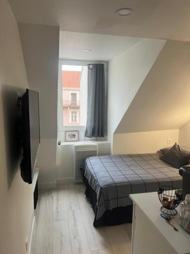 une petite pièce avec un lit et une fenêtre dans l'établissement Studio 5 minutes de la gare Grenoble, à Grenoble