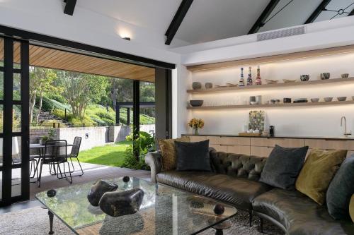 a living room with a leather couch and a table at Future Found Sanctuary, Luxury Boutique Hotel by NEWMARK in Cape Town