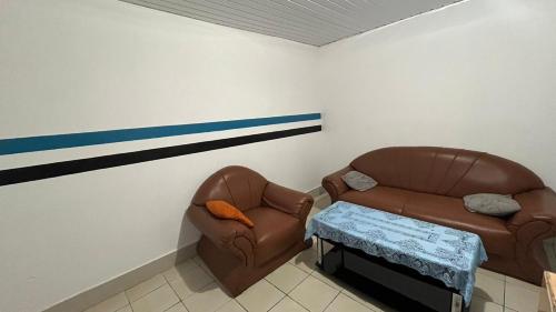 a living room with two chairs and a couch at Maison de vacance in Saint-Laurent du Maroni