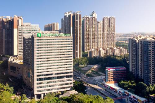 a tall building with a green dot on top of it at Wyndham Garden Foshan Jinshazhou in Foshan