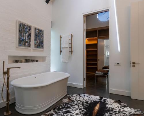 a white bathroom with a bath tub in a room at Future Found Sanctuary, Luxury Boutique Hotel by NEWMARK in Cape Town