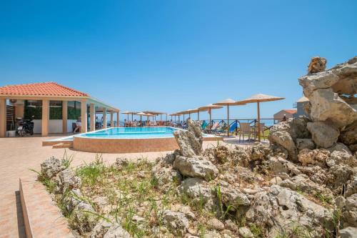 a resort with a swimming pool and some rocks at Kozanos Studios 1 in Amoudi