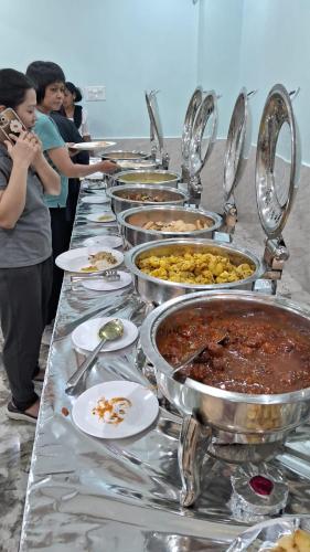 a buffet line with many different dishes of food at Hotel Gridhakuta International in Rājgīr