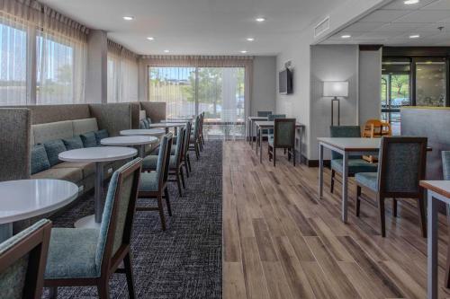 a dining room with tables and chairs and windows at Hampton Inn Detroit Northville in Northville