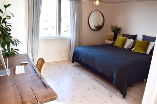 a bedroom with a bed and a table and a mirror at Northern lights Luxury with hot tub! 10 min to city in Mosfellsbær