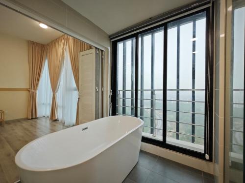 a white bath tub in a bathroom with a large window at Southkey Mosaic by Antlerzone in Johor Bahru