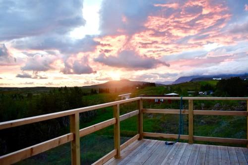 a view of a sunset from the deck of a house at Northern lights Luxury with hot tub! 10 min to city in Mosfellsbær