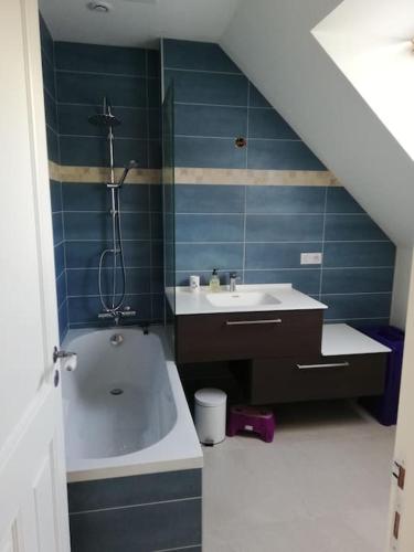 une salle de bain avec une baignoire et un lavabo dans l'établissement Maison de pêcheur restaurée 2022 à 800 m de la plage, GR34, à Moëlan-sur-Mer
