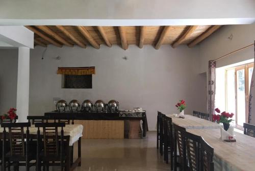 a dining room with tables and chairs in a room with a unintention at Kailash Nubra Valley Ladakh by LexStays in Nubra
