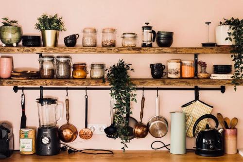 a kitchen with wooden shelves with pots and pans at Northern lights Luxury with hot tub! 10 min to city in Mosfellsbær