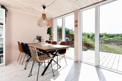 a dining room with a wooden table and chairs at Northern lights Luxury with hot tub! 10 min to city in Mosfellsbær