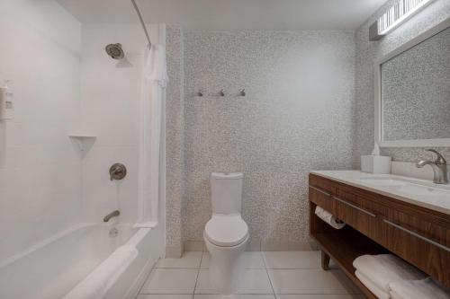 a bathroom with a toilet and a tub and a sink at Home2 Suites by Hilton Stillwater in Stillwater