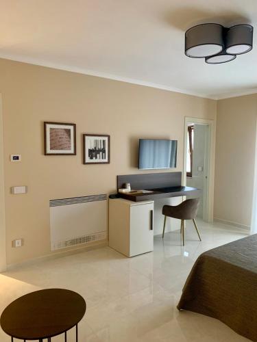 a bedroom with a bed and a desk and two chairs at Anna House in San Marco dei Cavoti
