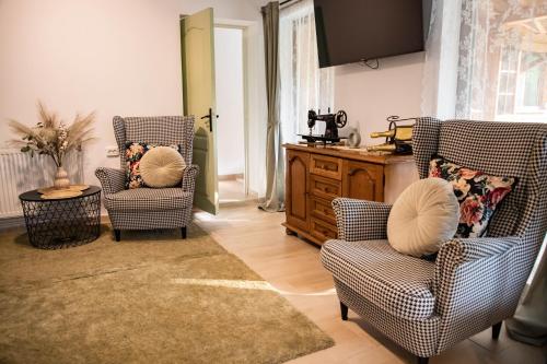 a living room with two chairs and a table at ADORA River Retreat in Avrig