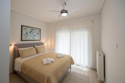a bedroom with a bed with two towels on it at Lux 1-bedroom condo-L&L Refuge in Athens