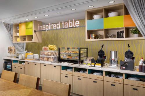 a fast food restaurant with aoked table with chairs at Home2 Suites By Hilton Clermont in Clermont