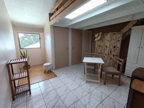 a living room with a table and chairs at Chambre cosy in Saint-Paul