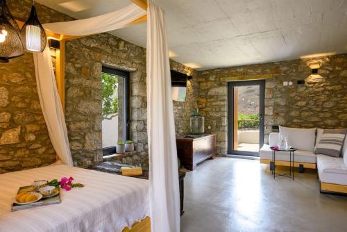 a bedroom with a bed and a living room with a couch at The Nektar House in Epáno Loúmas