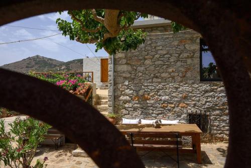 a wooden table in front of a stone building at The Nektar House in Epáno Loúmas