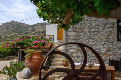 a wooden chair in front of a building with flowers at The Nektar House in Epáno Loúmas