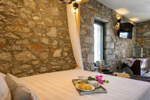 a bed with a tray of fruit on it at The Nektar House in Epáno Loúmas