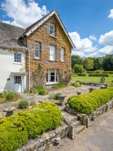 una casa in pietra con un giardino di fronte di Overtown Manor Bed and Breakfast a Swindon
