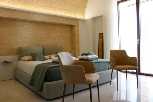 a bedroom with a bed and two chairs at Villa Agata in Lido Marini