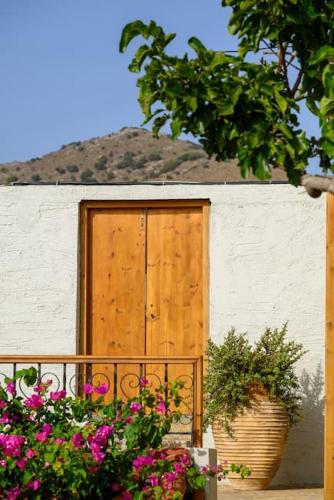 a wooden door on the side of a building with flowers at The Nektar House in Epáno Loúmas