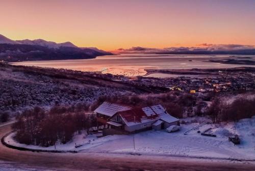 an aerial view of a house in the snow at sunset at Wyndham Garden Ushuaia Hotel del Glaciar in Ushuaia