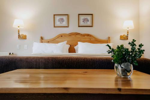 a bedroom with a bed and a table with a vase on it at Wyndham Garden Ushuaia Hotel del Glaciar in Ushuaia