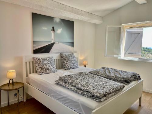 - une chambre avec un lit et une photo de phare dans l'établissement Maison Ciel et Mer, à Grimaud