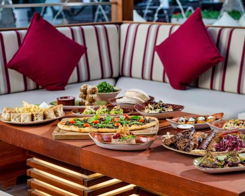 a table with many plates of food on it at Hyatt Regency Oryx Doha in Doha