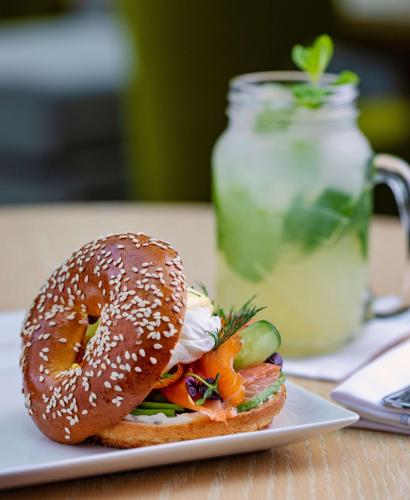 a bagel sandwich on a plate on a table at Hyatt Regency Oryx Doha in Doha