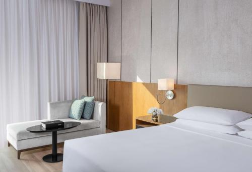 a hotel room with two beds and a chair at Hyatt Regency Oryx Doha in Doha
