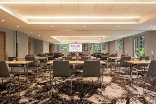 a conference room with tables and chairs and a projection screen at Dolce by Wyndham Versailles - Domaine du Montcel in Jouy-en-Josas