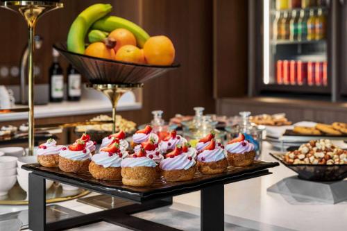 a buffet of cupcakes and fruit on a table at Dolce by Wyndham Versailles - Domaine du Montcel in Jouy-en-Josas