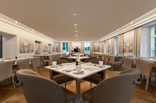 a restaurant with tables and chairs in a room at Dolce by Wyndham Versailles - Domaine du Montcel in Jouy-en-Josas