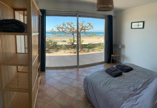 une chambre avec un lit et une vue sur la plage dans l'établissement appartement spacieux front de mer, au Grau-du-Roi