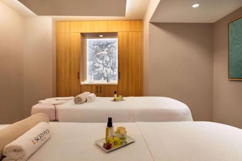a hotel room with two beds and a tray of food at Dolce by Wyndham Versailles - Domaine du Montcel in Jouy-en-Josas