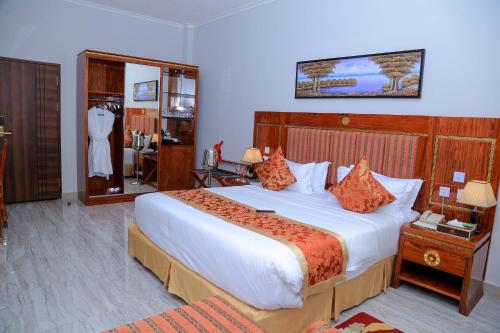 a hotel room with a large bed and a mirror at Tiffany Diamond Hotels LTD - Makunganya in Dar es Salaam